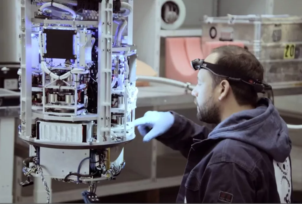A man with a flashlight on his head making the final preparation of an experiment module.