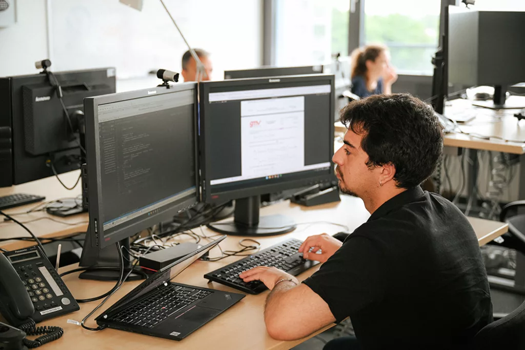 Engineer working at an office in front of a screen.