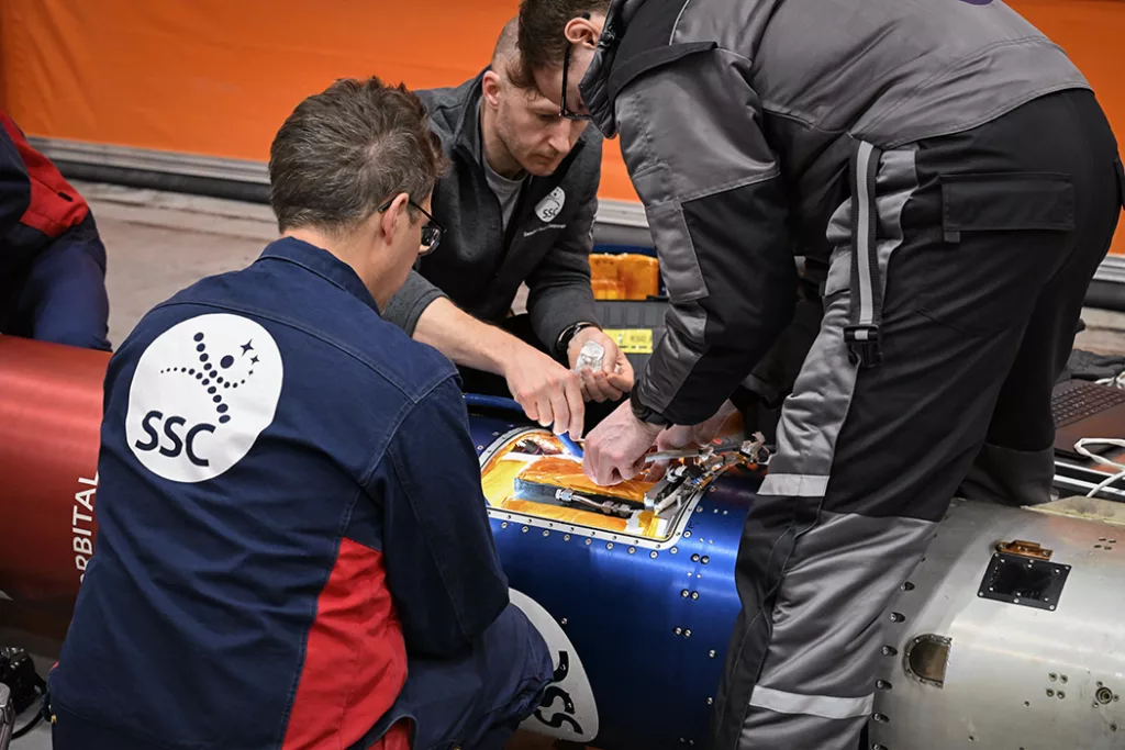 Engineers working with a payload