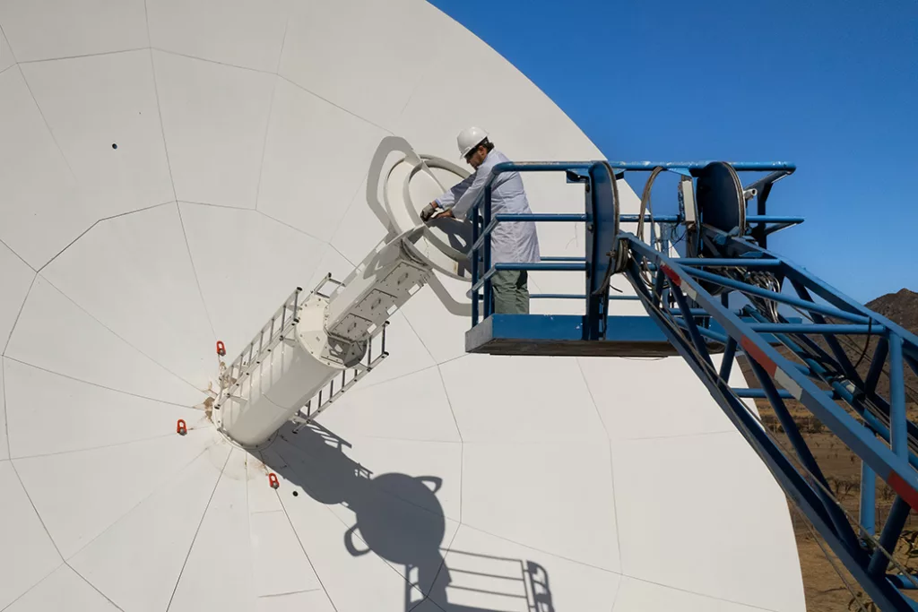 Man in a skylift maintaining an antenna
