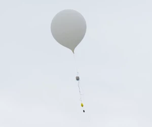 A captive balloon was used to lift the CanSats to 150 m altitude before dropping them towards the ground. Balloon flying in the sky